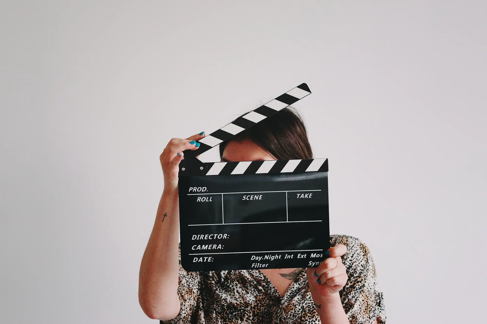 Yüzünün önünde film klaketi tutan bir kadın