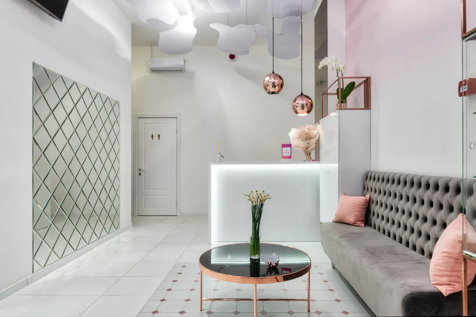 Beyaz ve pembe tonlarda sakin bir bekleme alanı ve resepsiyon
