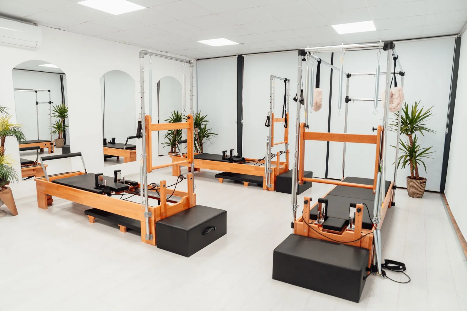 Ahşap reformer aletleriyle aydınlık bir pilates stüdyosu