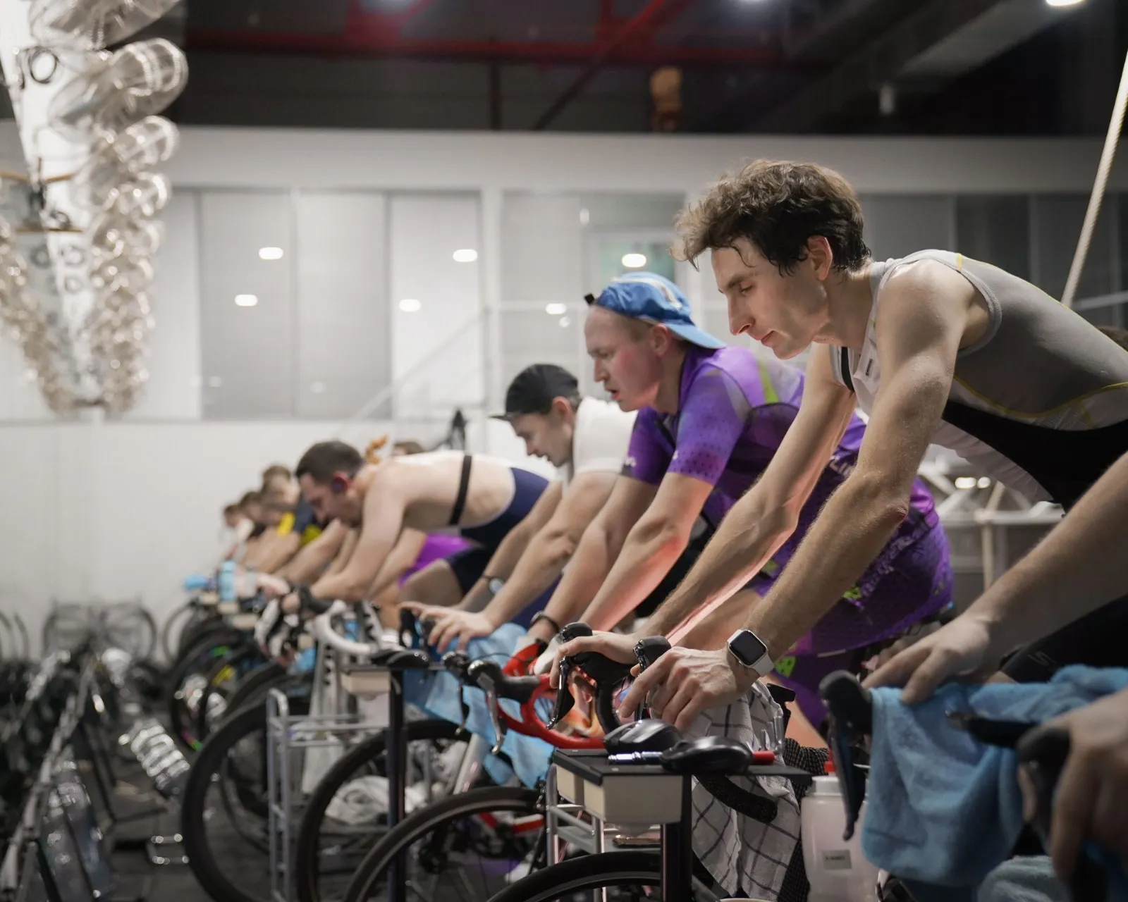 Kapalı salonda grup halinde spinning dersi yapan üyeler